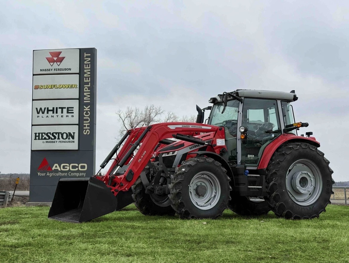A Massey Ferguson 5S parked outside on the lawn in front of a Shuck Implement sign.